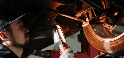 man in blue dress shirt holding brown wooden tool