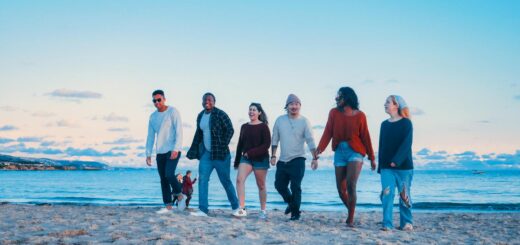 group of friends walking on beach shore