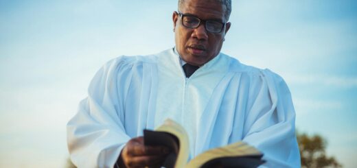 priest in glasses looking through a book